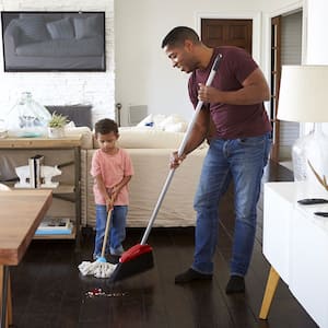 Father and son sweeping the dining room 